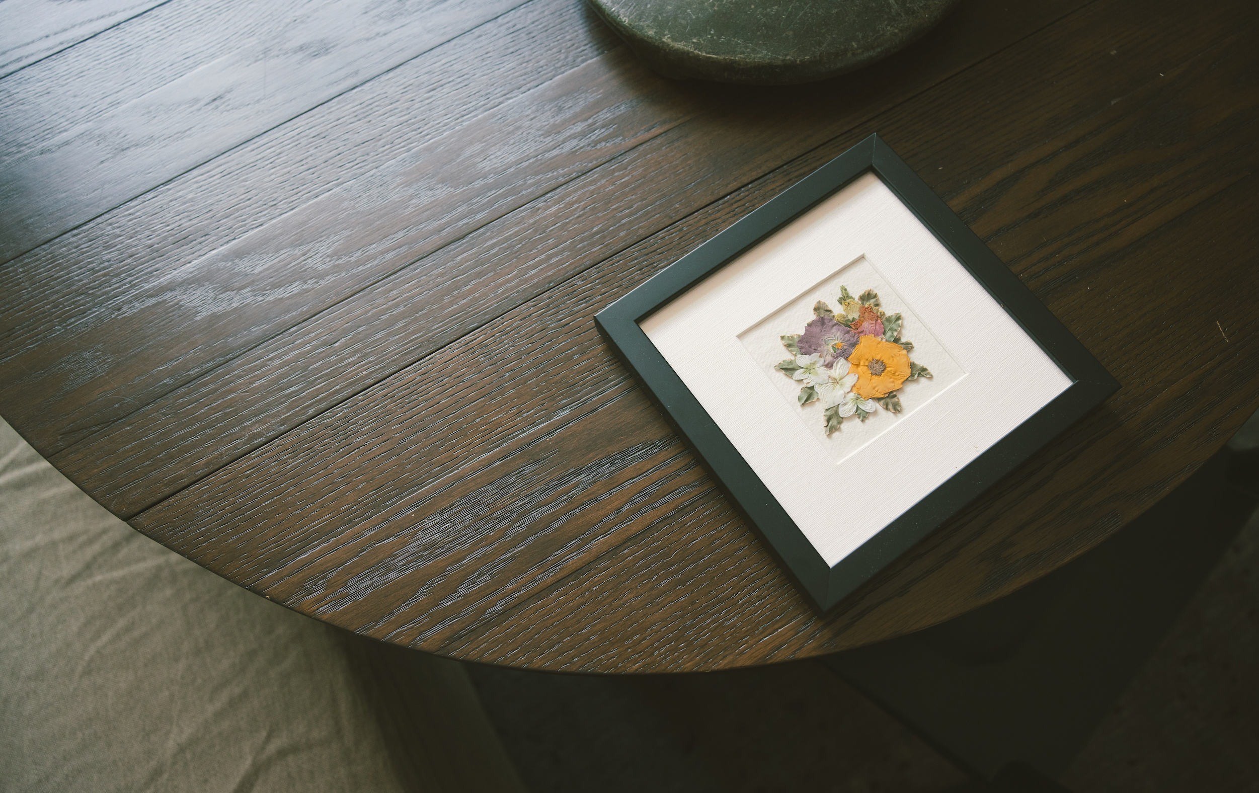 Framed artwork with floral design on a wooden surface